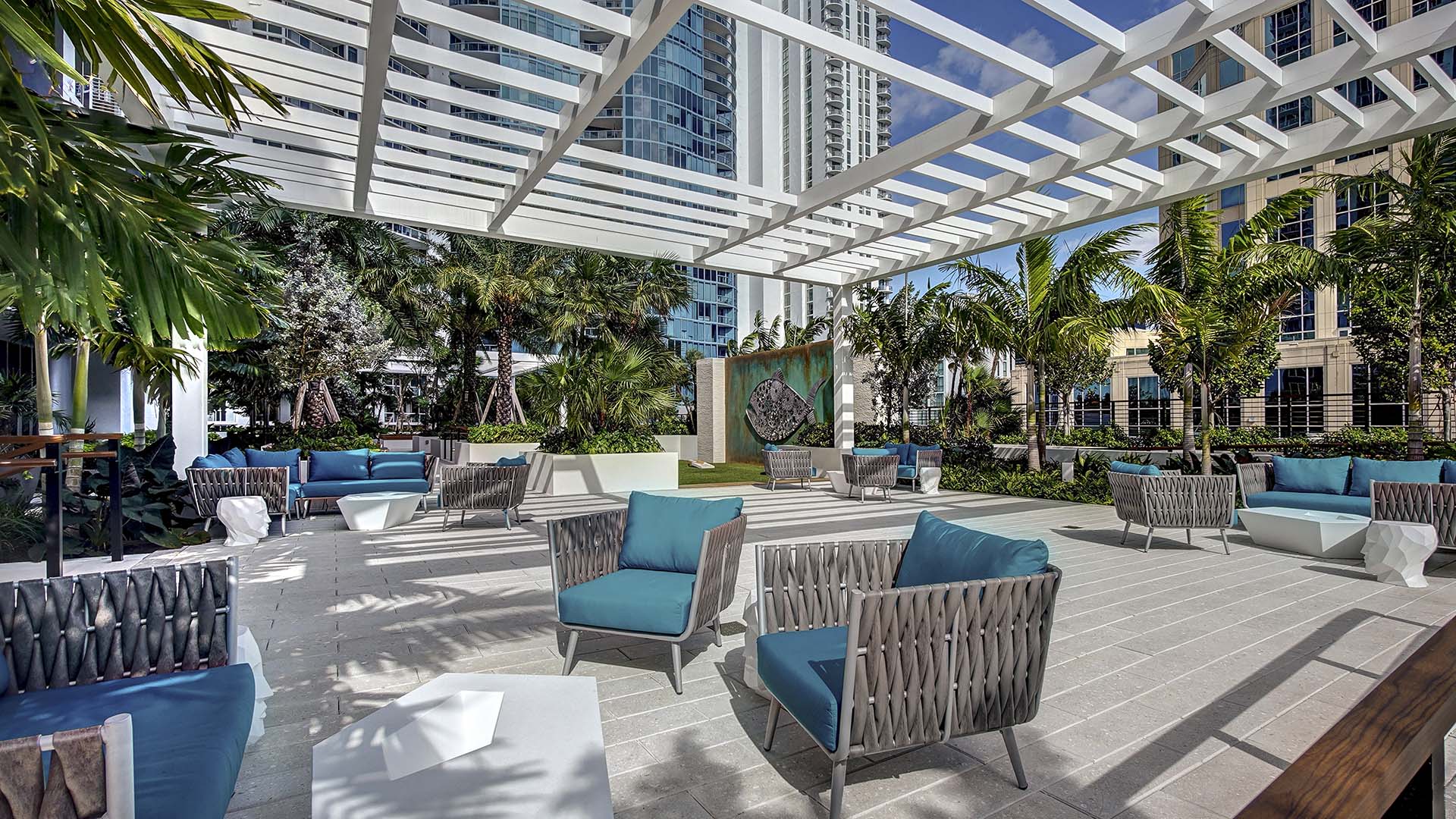 Rooftop lounge with chairs, gazebo, and coffee tables.